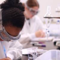 Student writing down notes on a notepad